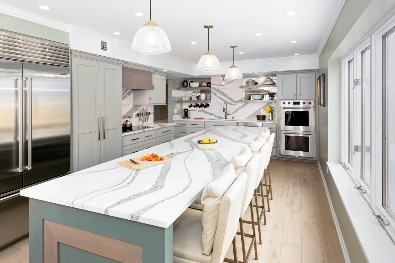 Kitchen with gray cabinets featuring a counter and island with Cambria Annicca quartz countertops.