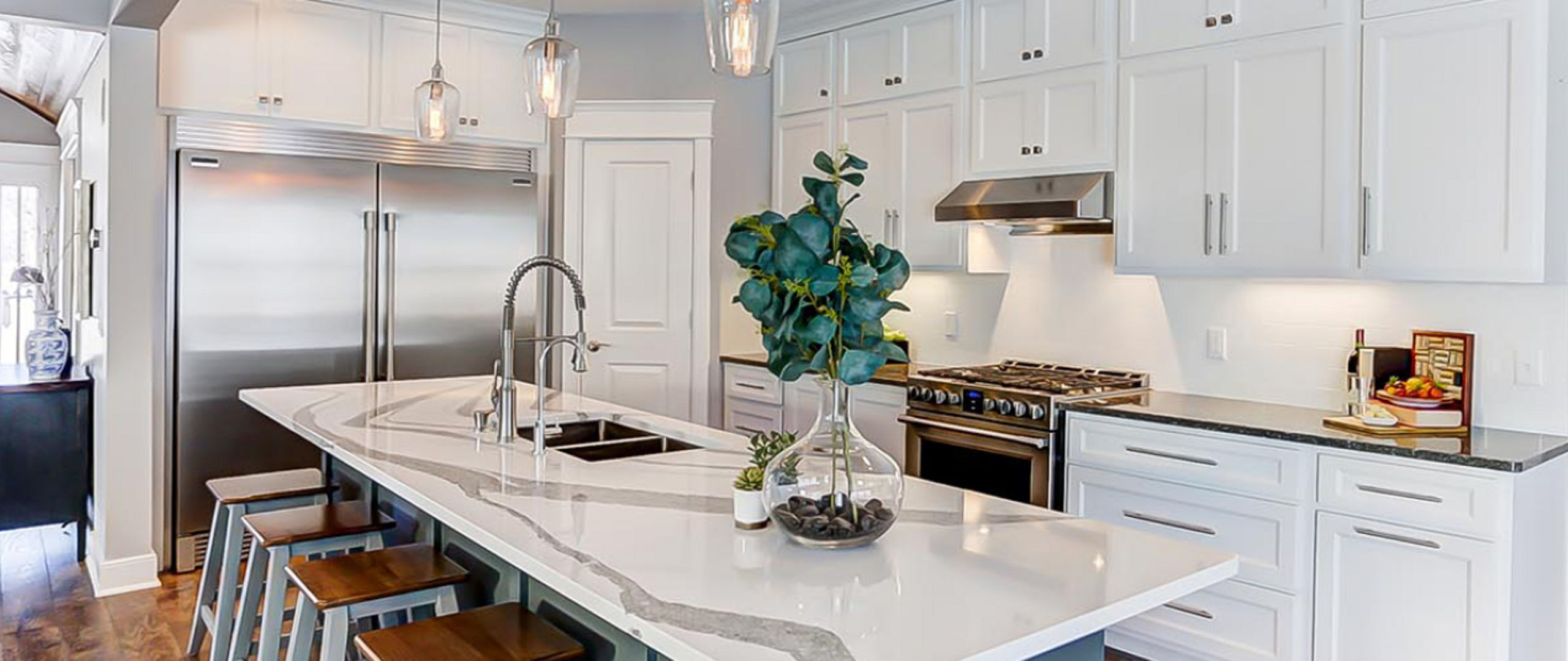 Side view of a kitchen and island area with Cambria Minera countertops around the stove and Cambria Annicca countertops on the island