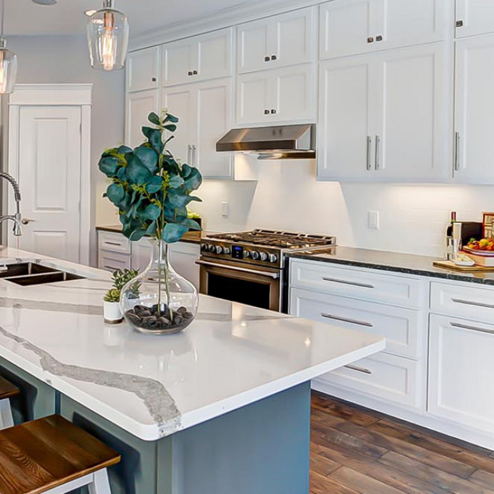 Side view of a kitchen and island area with Cambria Minera countertops around the stove and Cambria Annicca countertops on the island