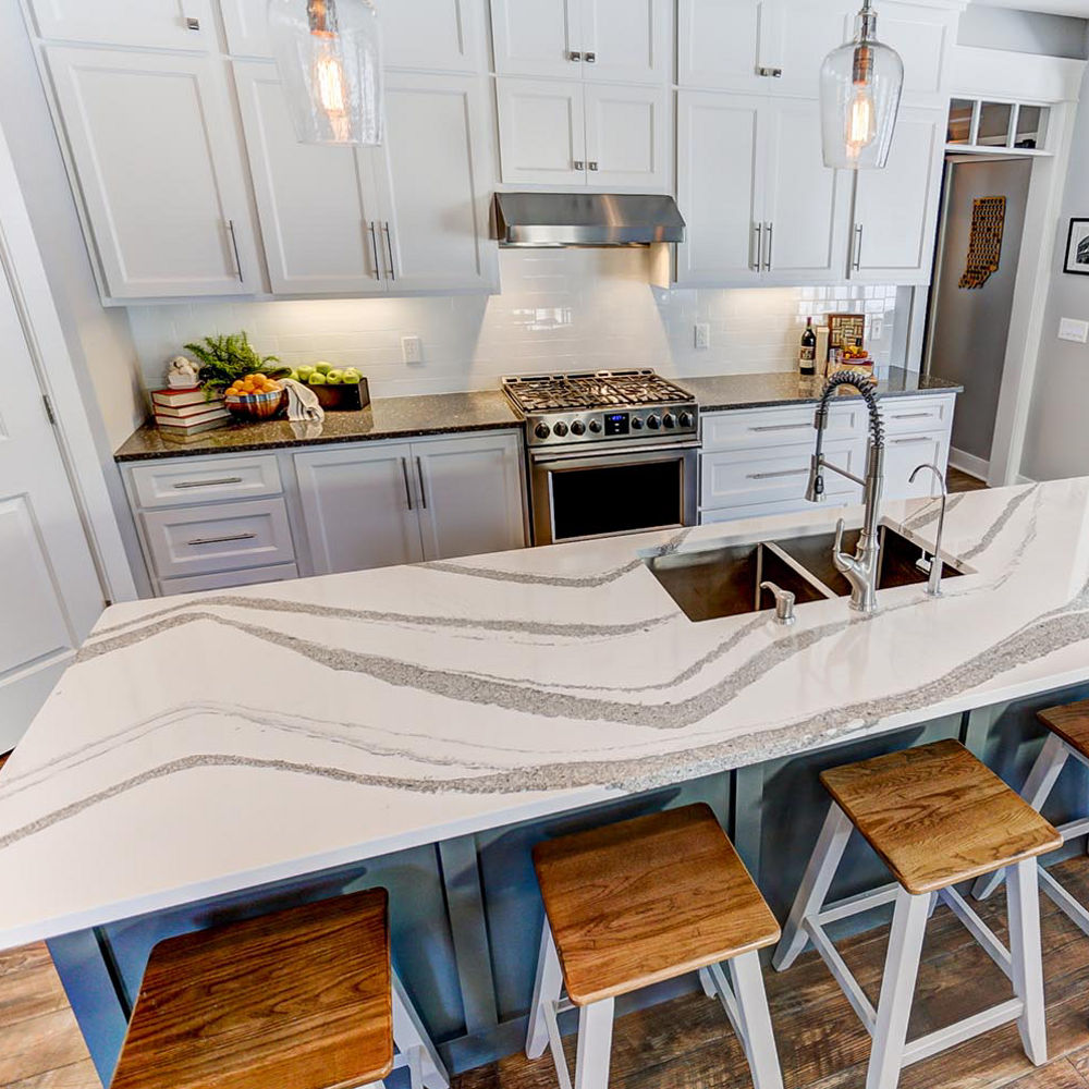 Overhead view of a kitchen and island area with Cambria Minera countertops around the stove and Cambria Annicca countertops on the island