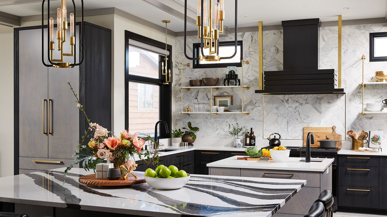 a bold, yet brilliant kitchen with black lower cabinets, open shelving, gold accents, and two islands, one of which is topped with black and white veined quartz countertops.
