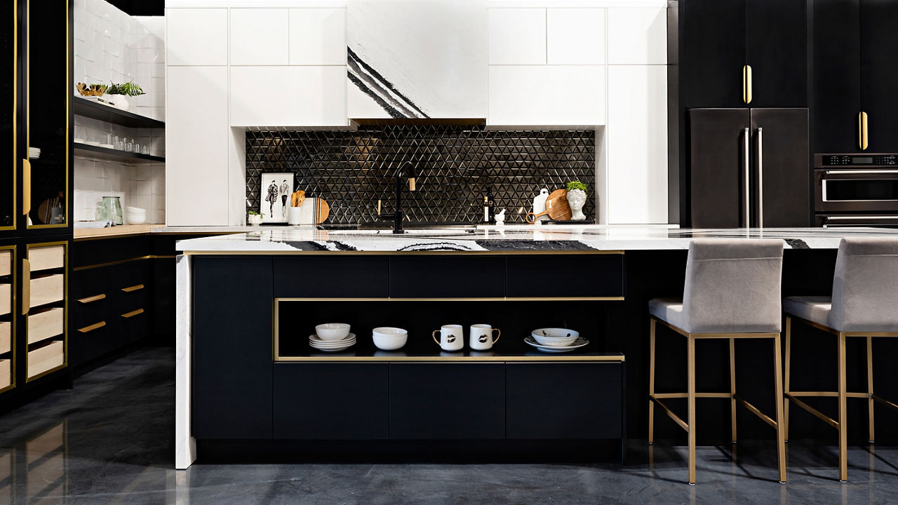 A kitchen with black cabinets with a focus on an island with Bentley quartz countertops.