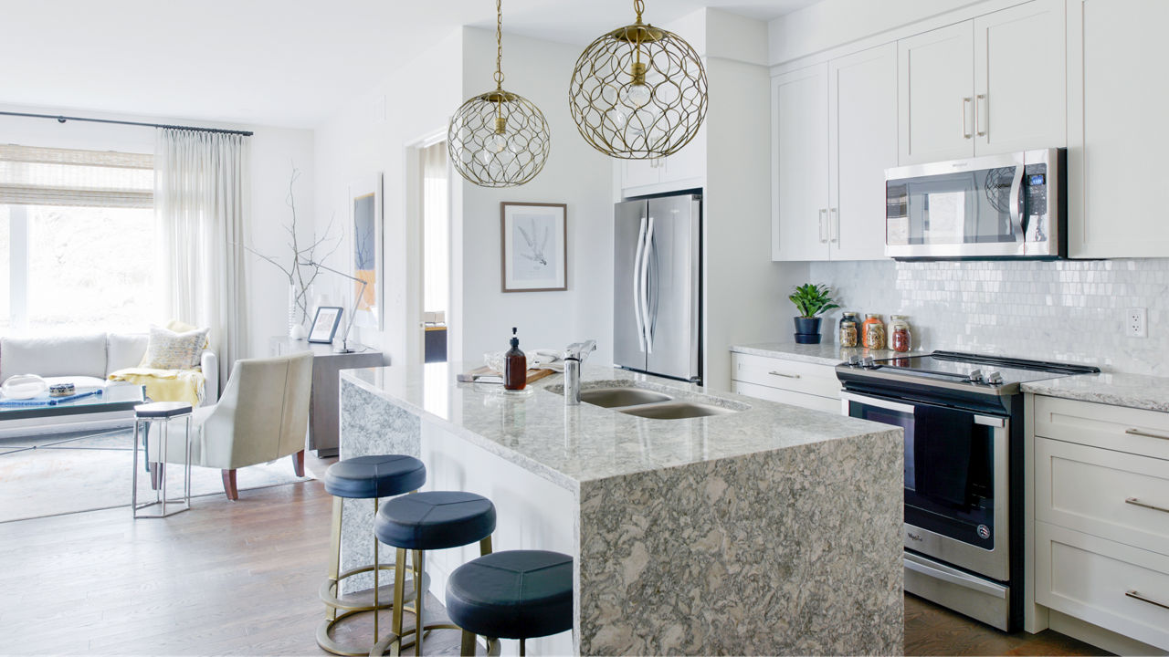 An open kitchen with a counter and kitchen island with Cambria Berwyn quartz siding and countertops.