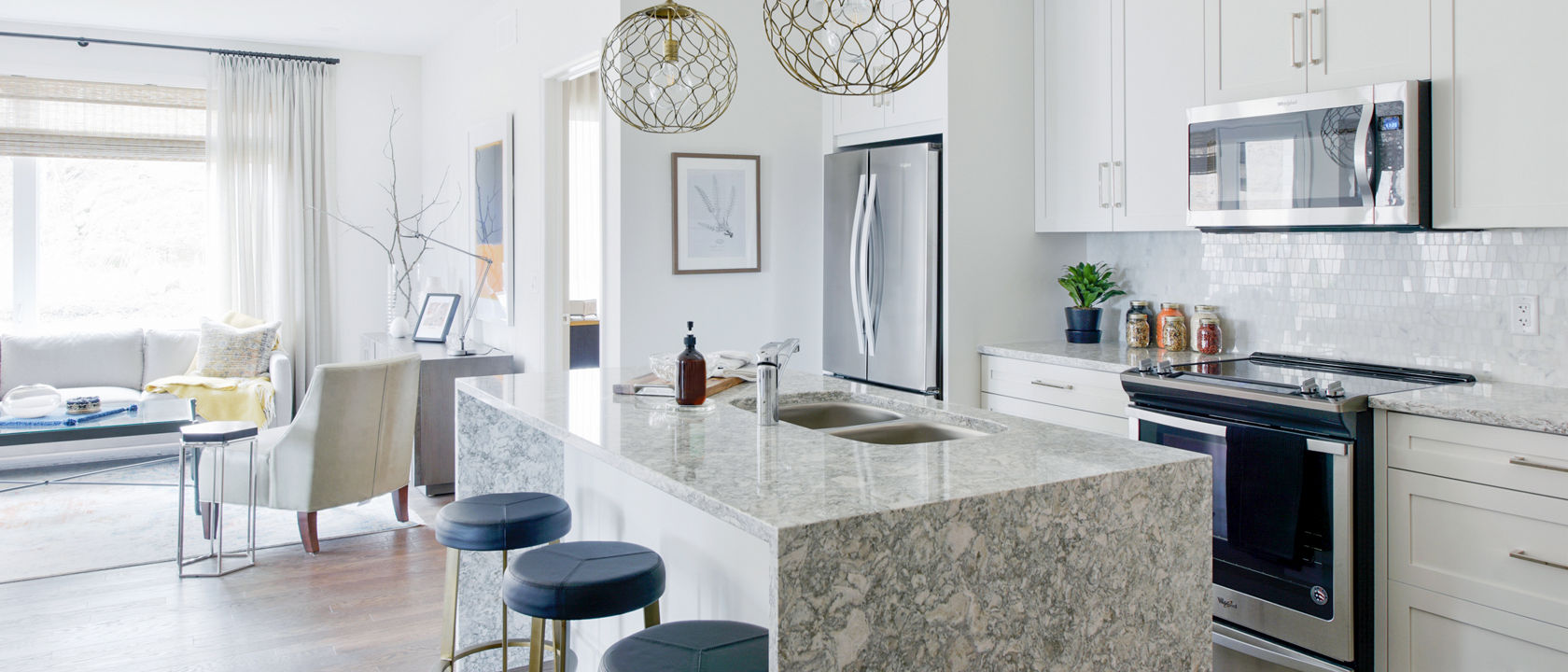 An open kitchen with a counter and kitchen island with Cambria Berwyn quartz siding and countertops.