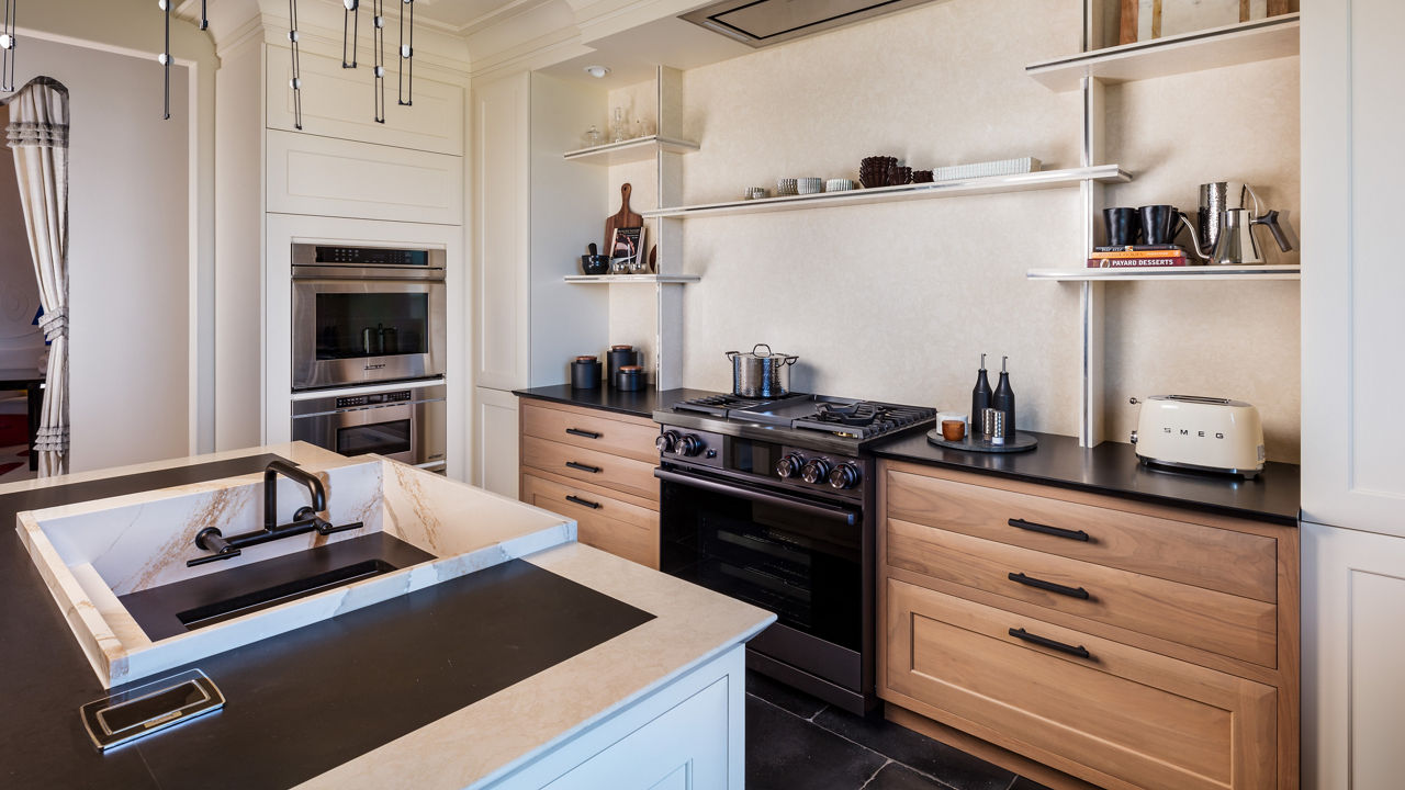 a modern kitchen with oak lower cabinets, white quartz backsplash and custom quartz shelving, a large sink in the island, and black accents throughout. 