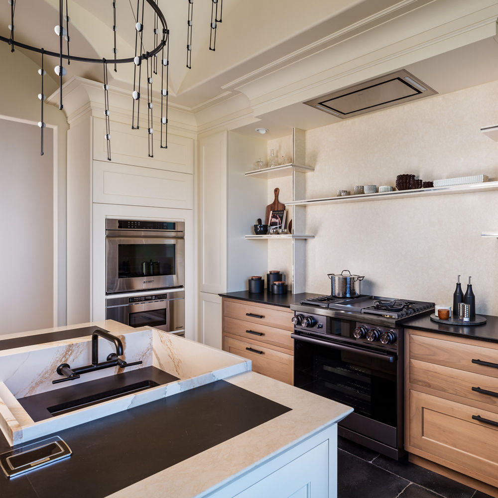 a modern kitchen with oak lower cabinets, white quartz backsplash and custom quartz shelving, a large sink in the island, and black accents throughout. 