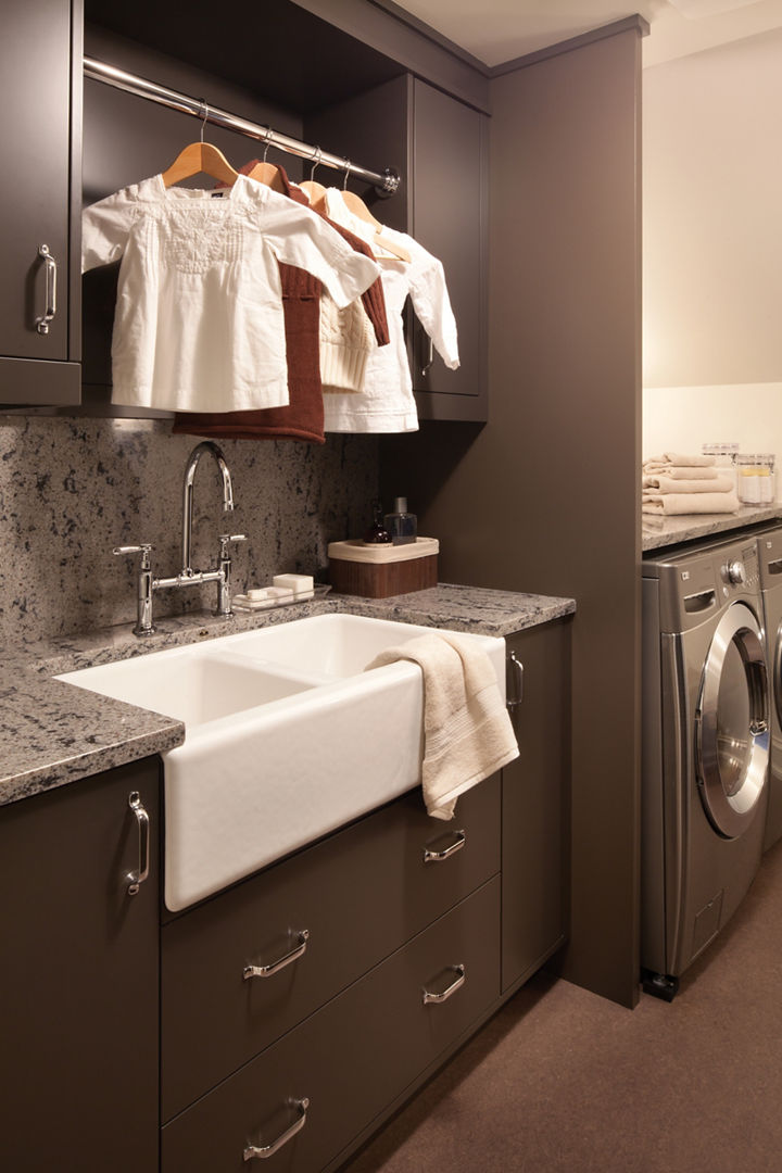 a laundry room with dark brown cabinets, a large utility sink, gray quartz countertops to provide a granite alternative, and hanging storage for drying clothes. 