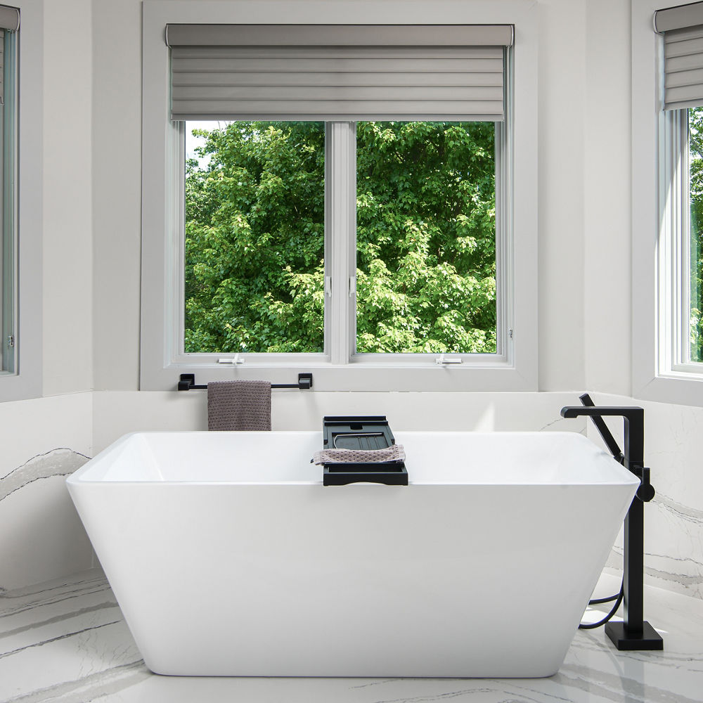 A bathroom featuring Cambria Brittanicca quartz flooring and siding beside a bathtub and window.