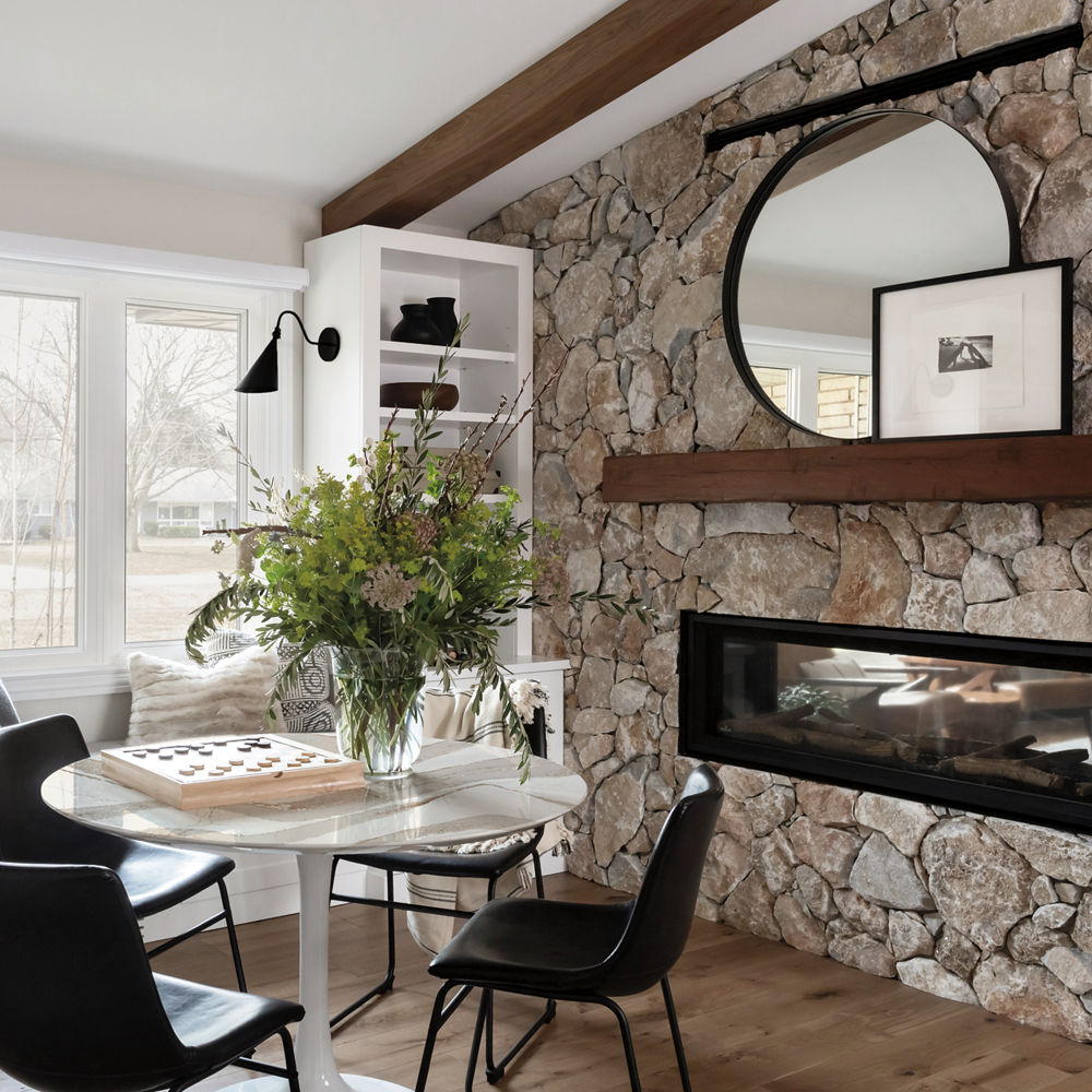 A fireplace area reading nook featuring a Brittanicca Gold table