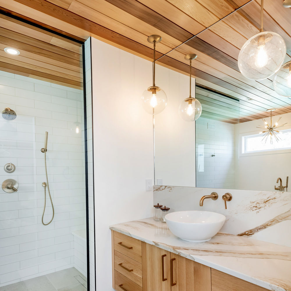 A bathroom with an oak ceiling and cabinets with a Brittanicca Gold Warm quartz vanity 