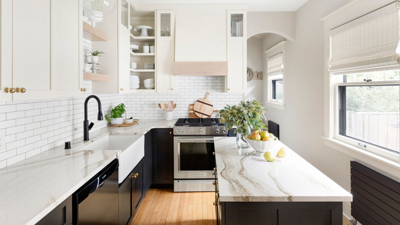 A bright white kitchen with a tile backsplash and Brittanicca Gold Warm quartz countertops