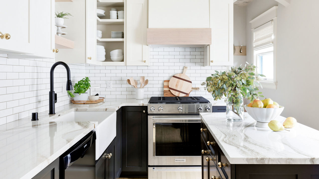 A bright white kitchen with a tile backsplash and Brittanicca Gold Warm quartz countertops