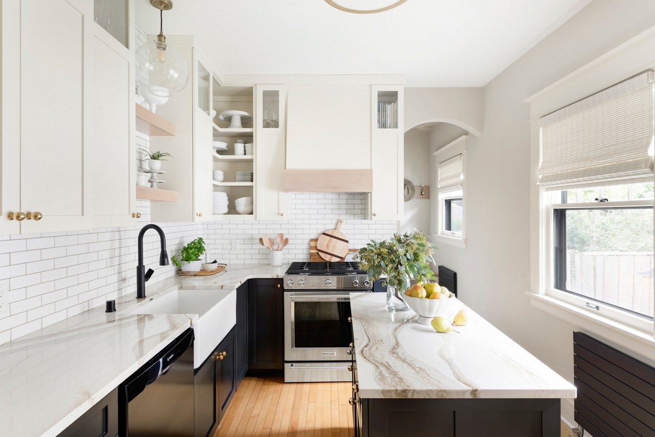 A bright white kitchen with a tile backsplash and Brittanicca Gold Warm quartz countertops