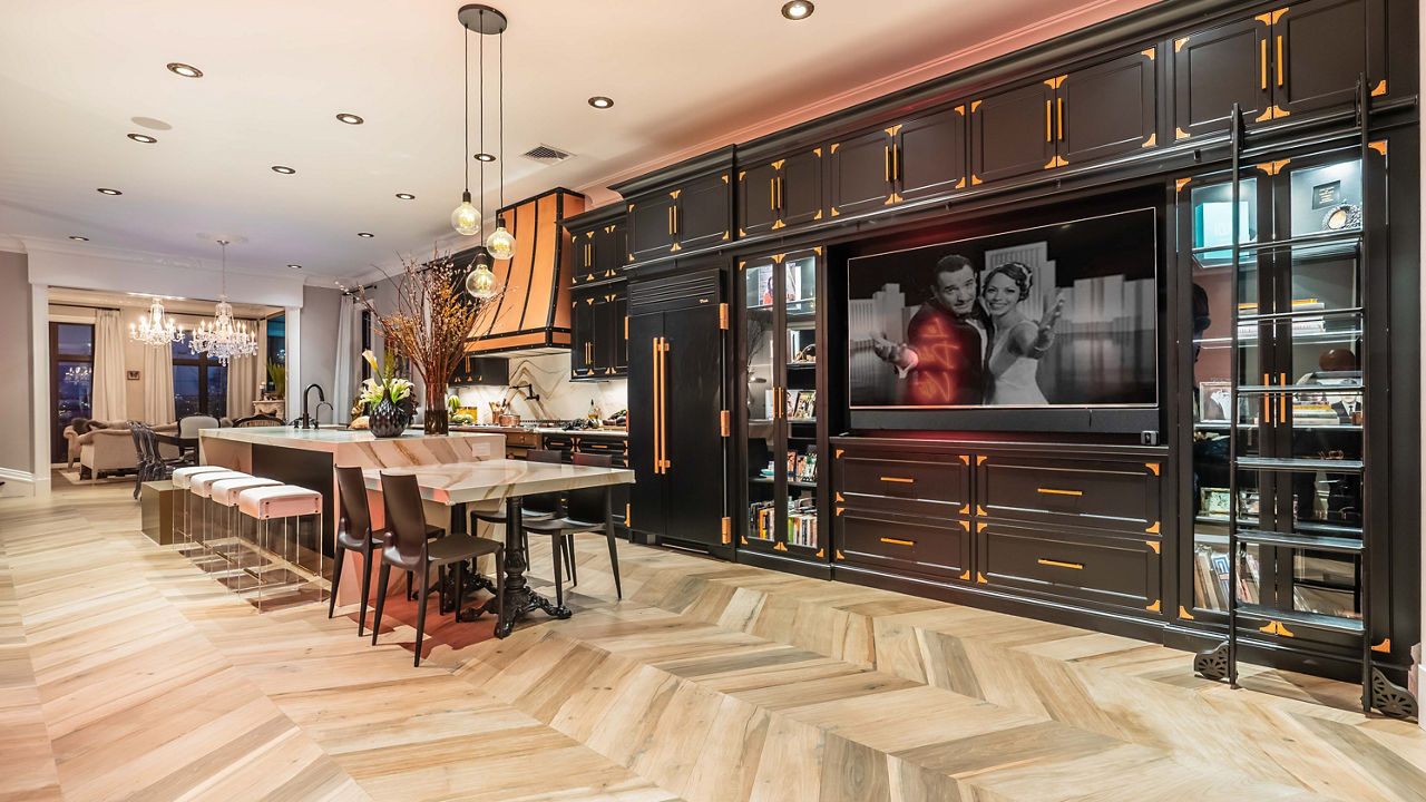 A modern kitchen with a massive island and backsplash with Cambria Brittanicca Gold Warm quartz creating a warm earth toned kitchen.