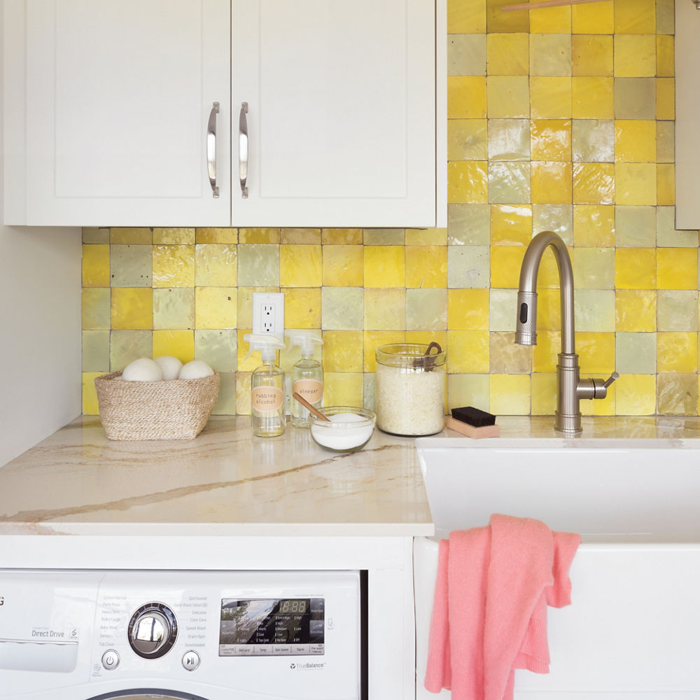 Closeup of the counter of a laundry room with a farmhouse sink and Cambria Brittanicca Gold quartz countertop