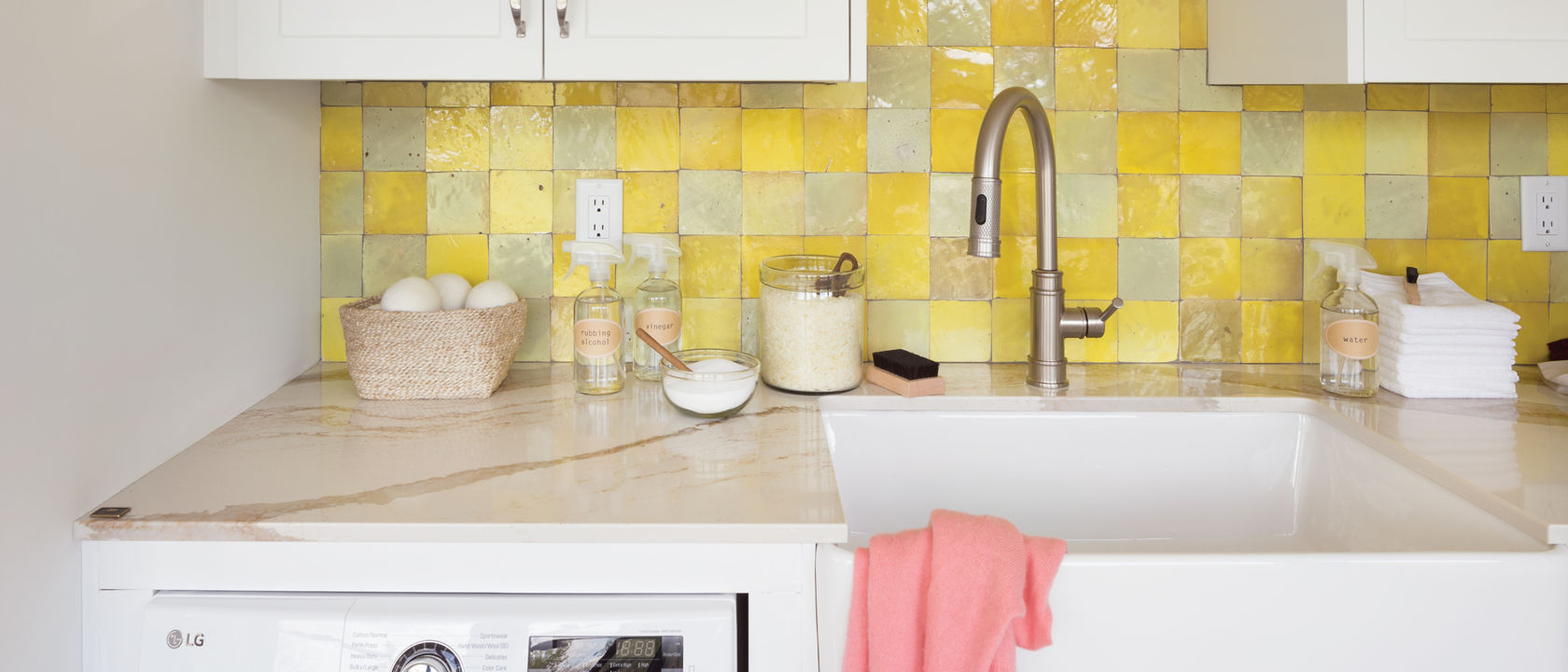 Closeup of the counter of a laundry room with a farmhouse sink and Cambria Brittanicca Gold quartz countertop