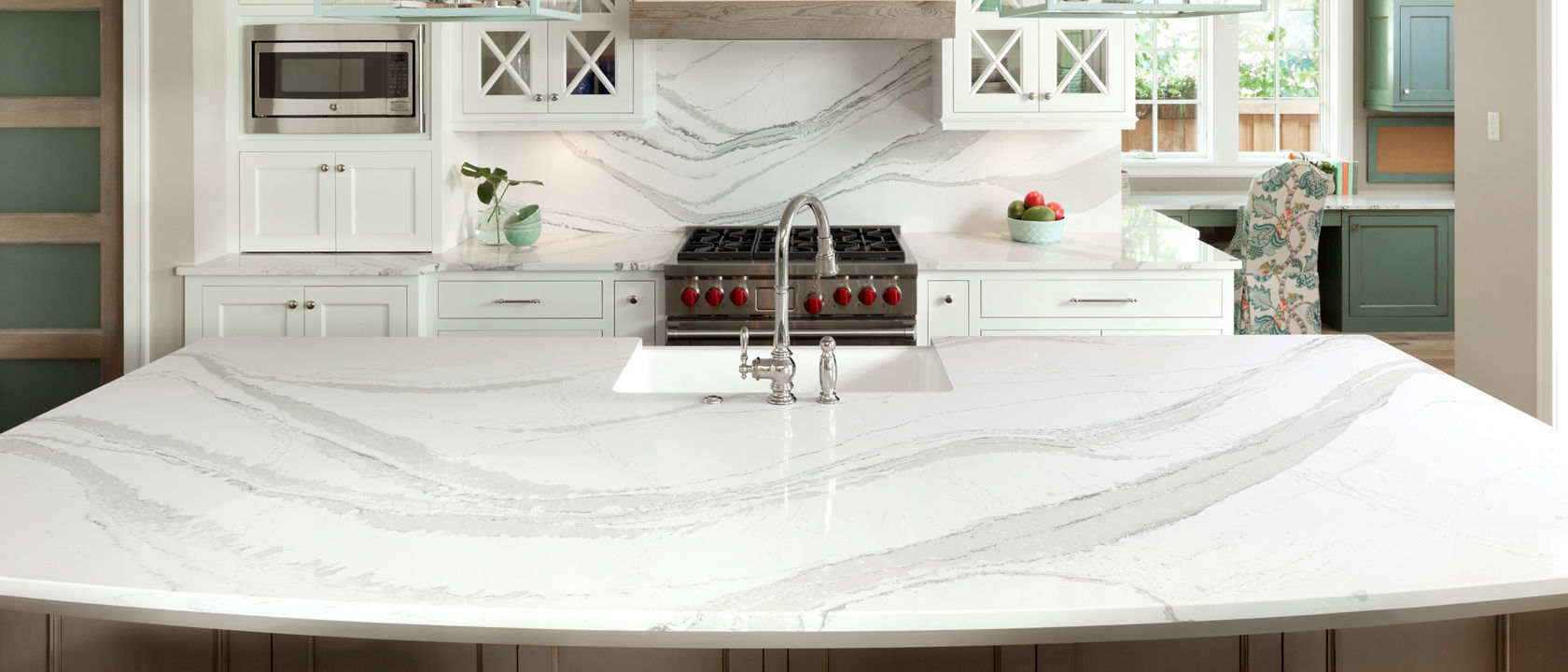 A kitchen island and backsplash featuring Cambria Brittanicca quartz.