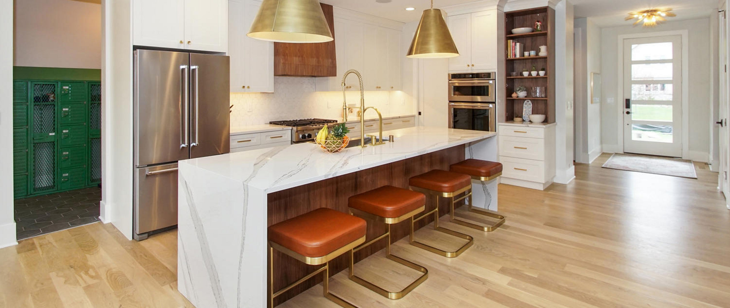 An elegant white and wood themed kitchen accented by Cambria Brittanicca quartz countertop