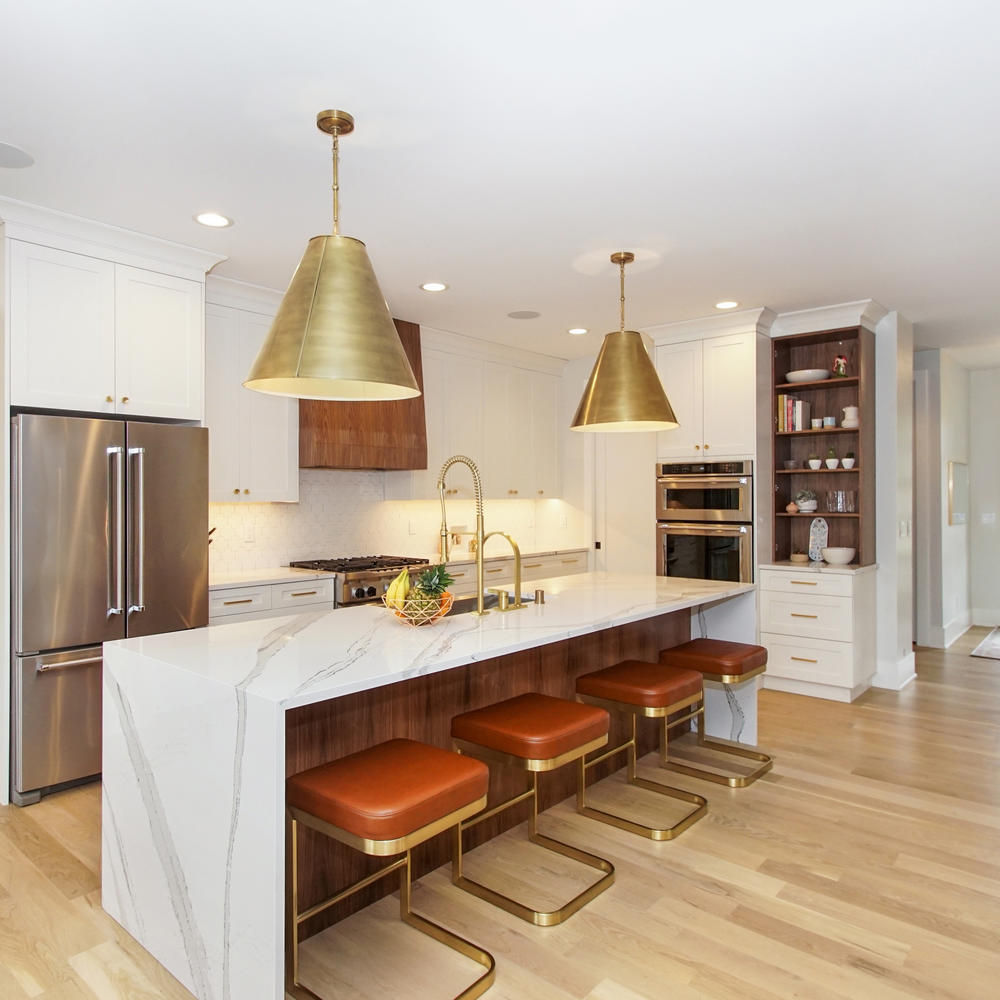 An elegant white and wood themed kitchen accented by Cambria Brittanicca quartz countertop