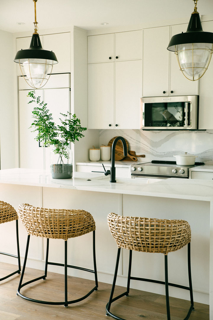 Two wooden stools in front of a kitchen island with a Cambria White Brittanicca quartz countertop.