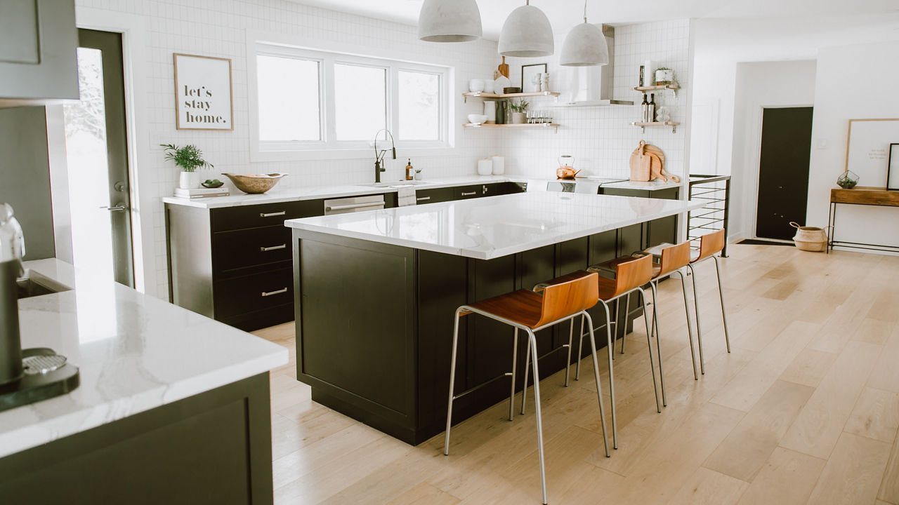 A cozy white kitchen with dark brown cabinets and Brittanicca quartz countertops by Jaclyn Peters