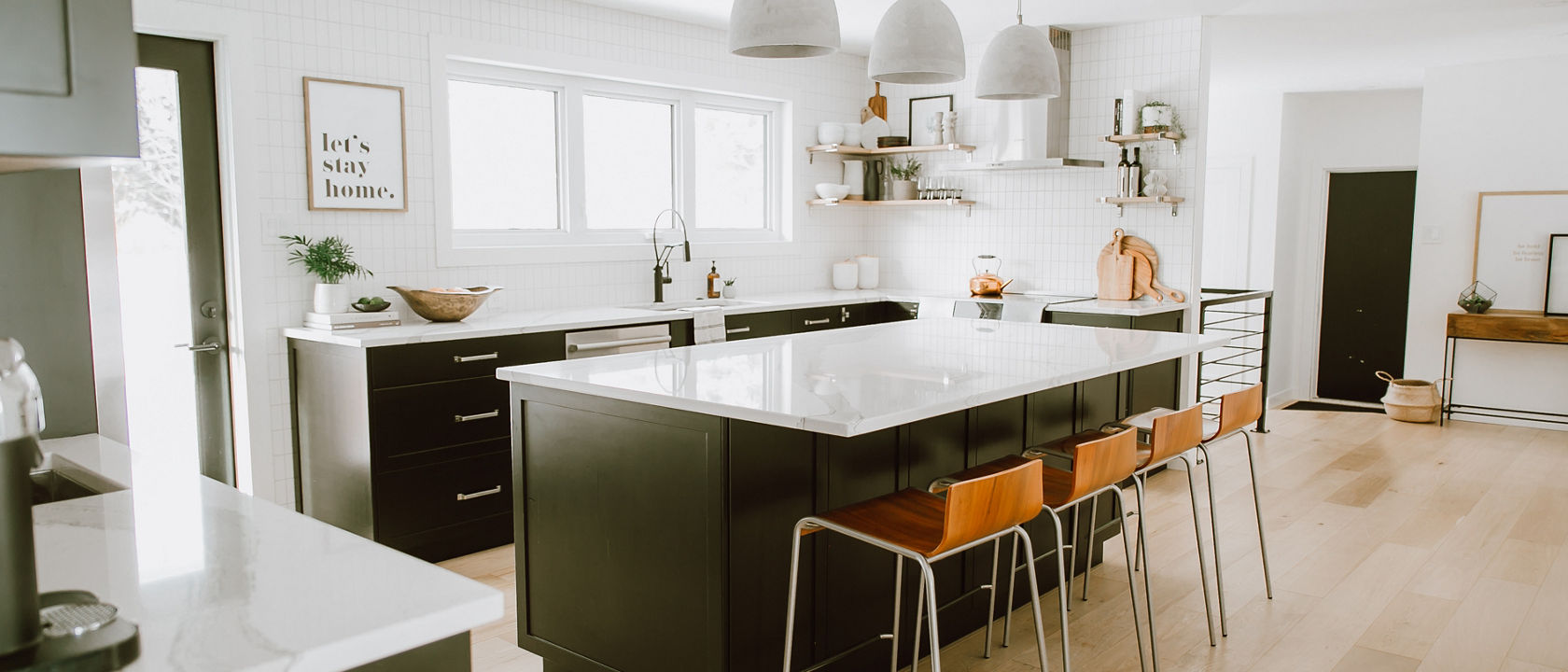 A cozy white kitchen with dark brown cabinets and Brittanicca quartz countertops by Jaclyn Peters