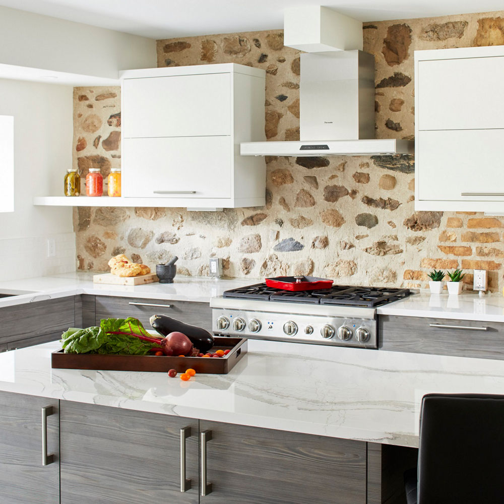 Kitchen featuring gray shelves, cupboards, and a counter and island with Cambria Brittanicca quartz countertops.