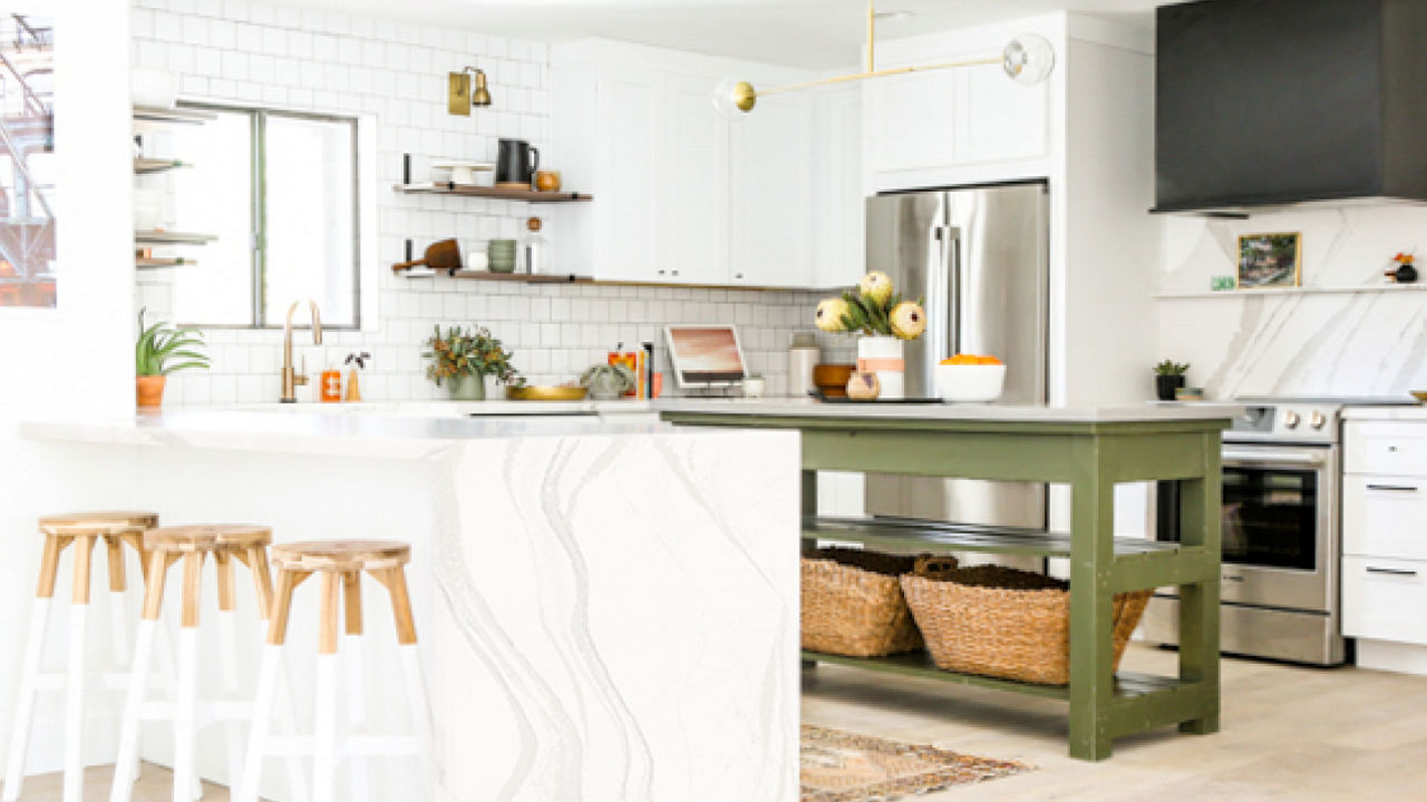 a rustic green kitchen with two islands one, made of white quartz with three barstools and the other island is open and painted olive green.