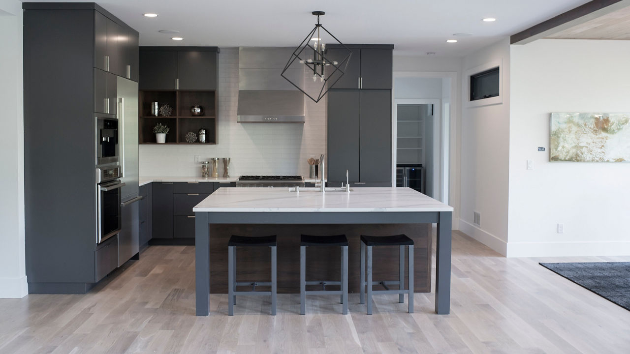 A gray kitchen with a counter and island with Brittanicca Matte countertops.