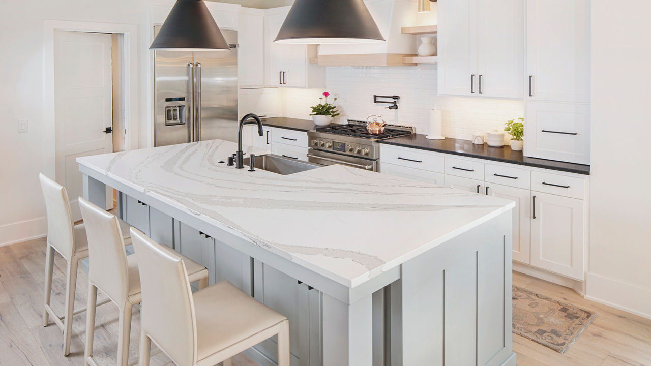 A bright, warm kitchen featuring an island with an anti-glare Cambria Matte quartz countertop.