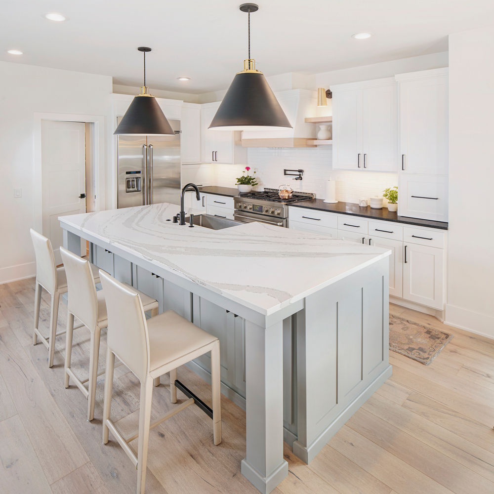 A bright, warm kitchen featuring an island with an anti-glare Cambria Matte quartz countertop.