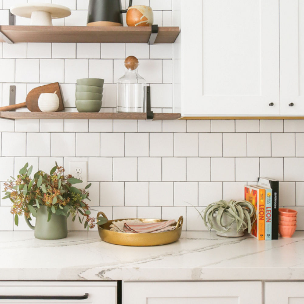 Wooden floating shelves hang over a kitchen counter featuring a Cambria Brittanicca Matte countertop.