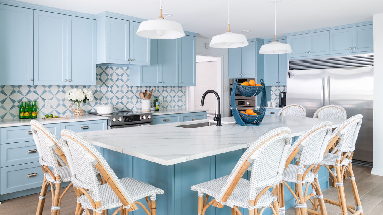 A kitchen with blue cabinetry and white Cambria Brittanicca Matte quartz countertops.