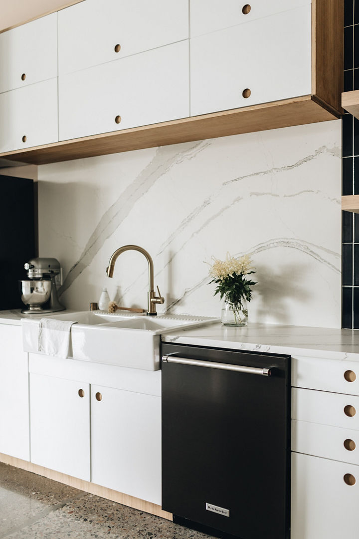 Cambria Brittanicca Matte countertop with farmhouse sink in black and white kitchen design