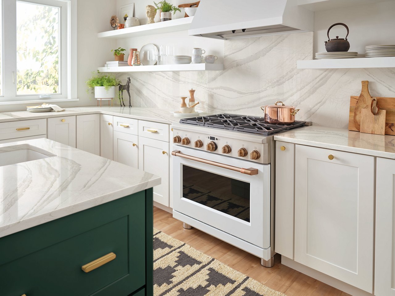 a kitchen with white cabinets, white quartz countertops and backsplash, white hood and range, open shelving, and a green island.