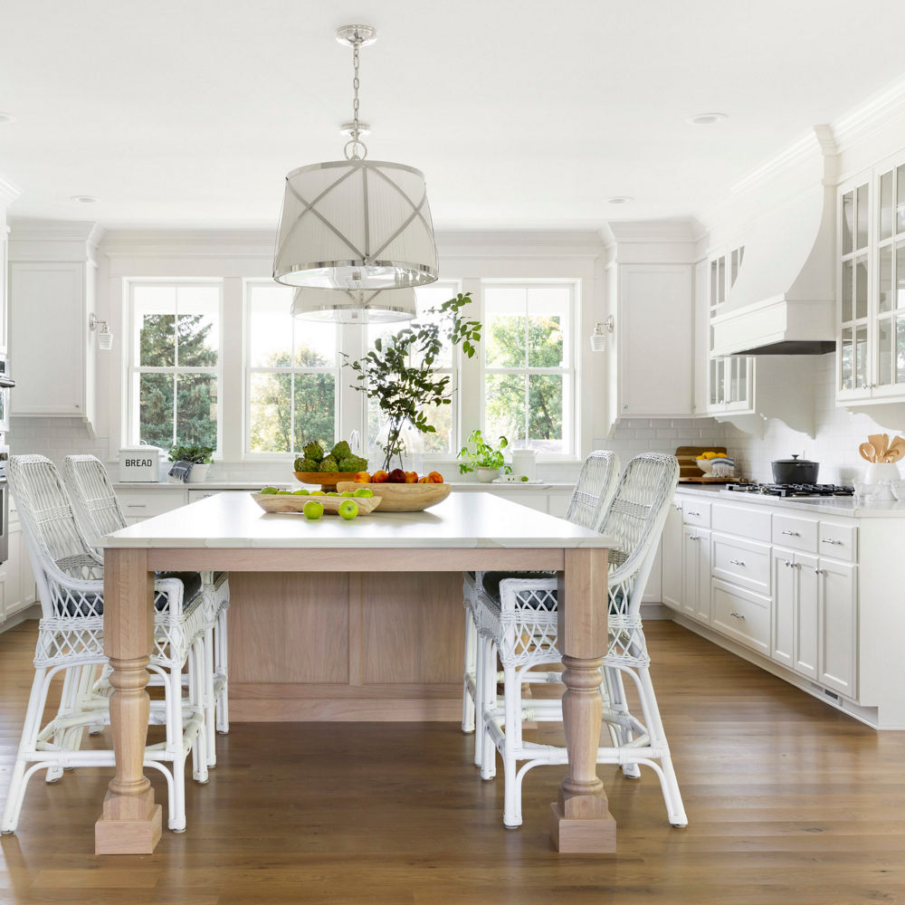 An elegant white themed kitchen accented by Cambria Brittanicca Warm quartz countertop and tabletop