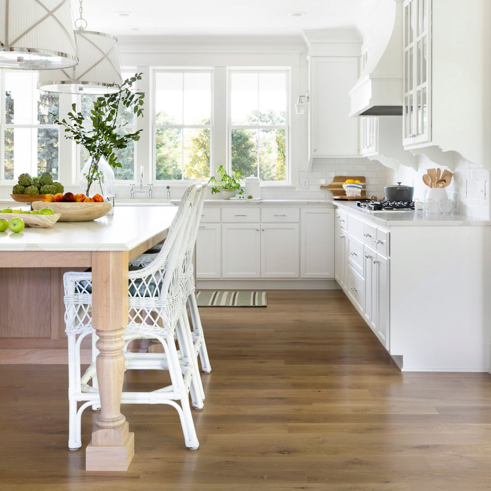 An open layout kitchen with Cambria Brittanicca Warm quartz countertops and tabletop