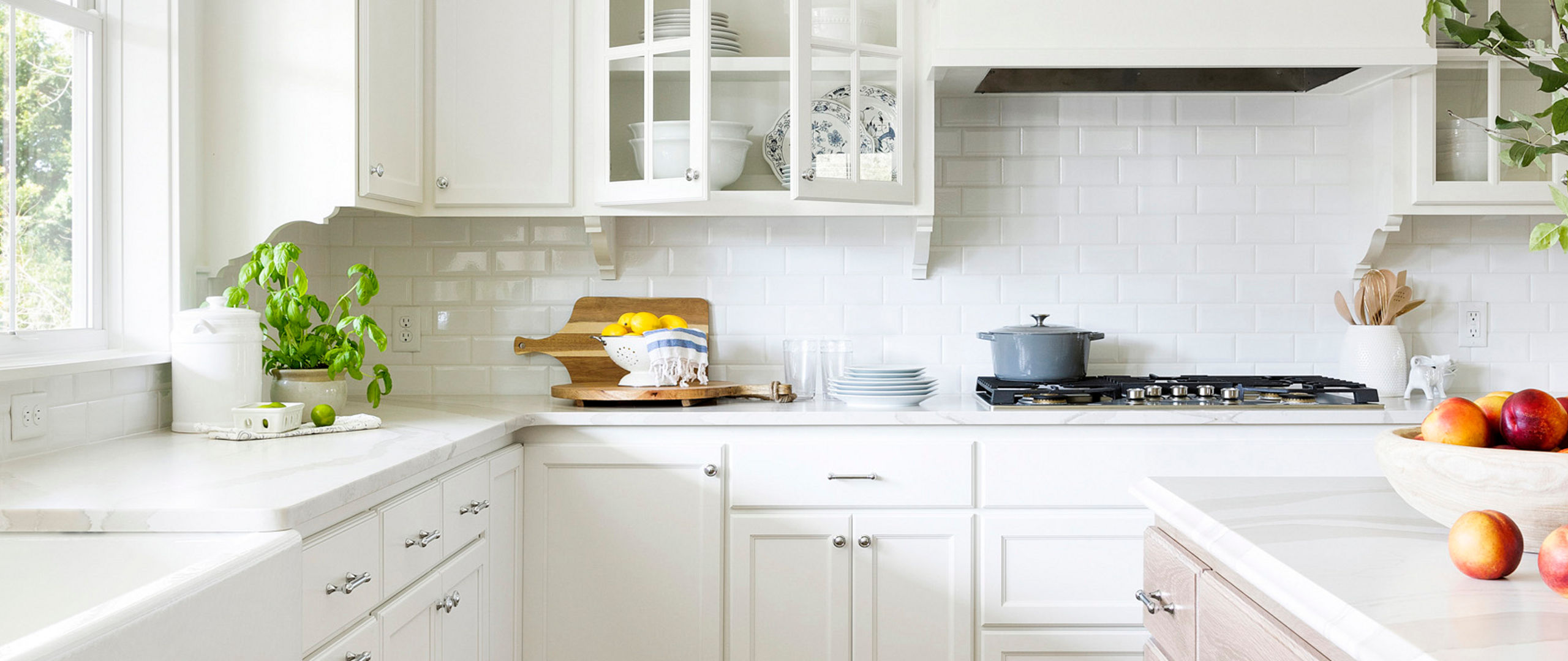An elegant white themed kitchen accented by Cambria Brittanicca Warm quartz countertop