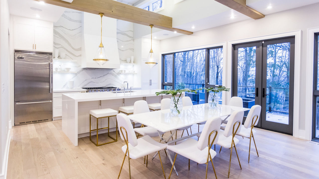 A kitchen featuring a table and island with Cambria Brittanicca quartz countertops.