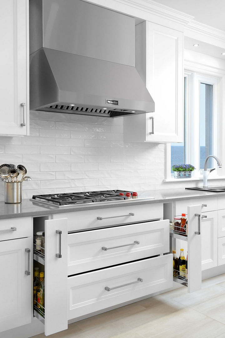 A kitchen featuring white narrow drawers and a utensil holder atop a Cambria Carrick quartz countertop.