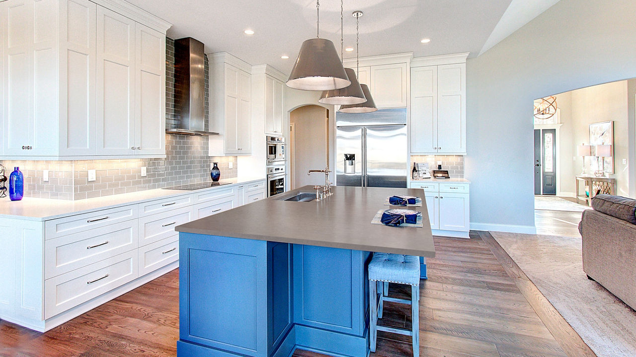 A beautifully sleek white and blue kitchen theme accessed by Cambria Carrick Matte and Swanbridge quartz countertops