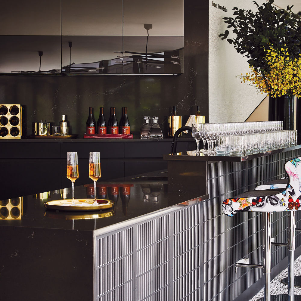 a lounge area with a bar topped with black quartz.