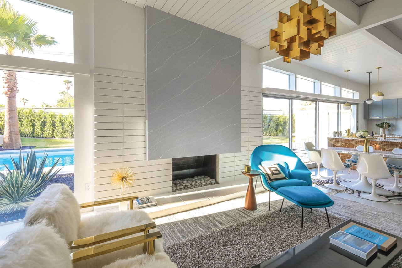A mid-century modern living room with a gray quartz fireplace. 