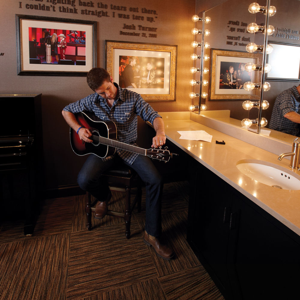 Josh Turner playing his guitar in the Grand Ole Opry. dressing room.