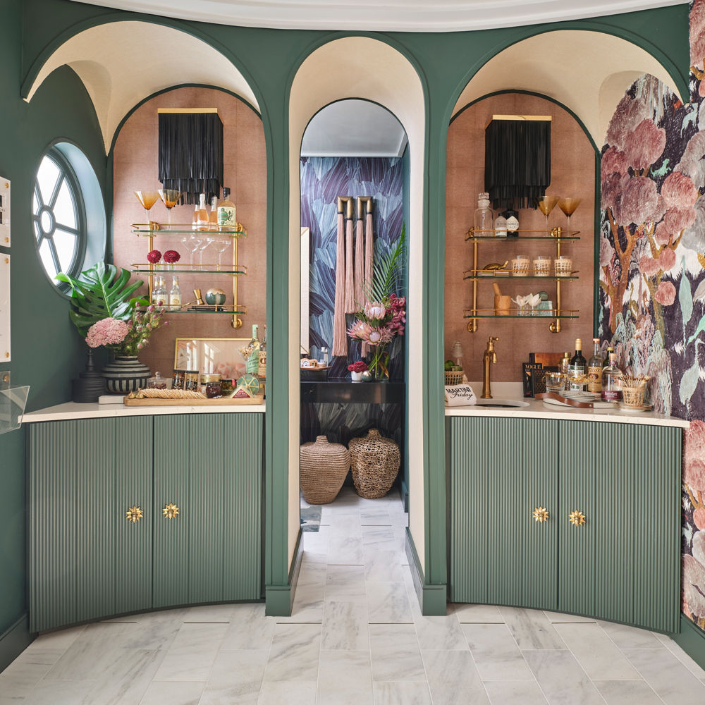 a gorgeous pool ball with sage green cabinets, white quartz countertops, rounded nook with open shelving, and an arched doorway.