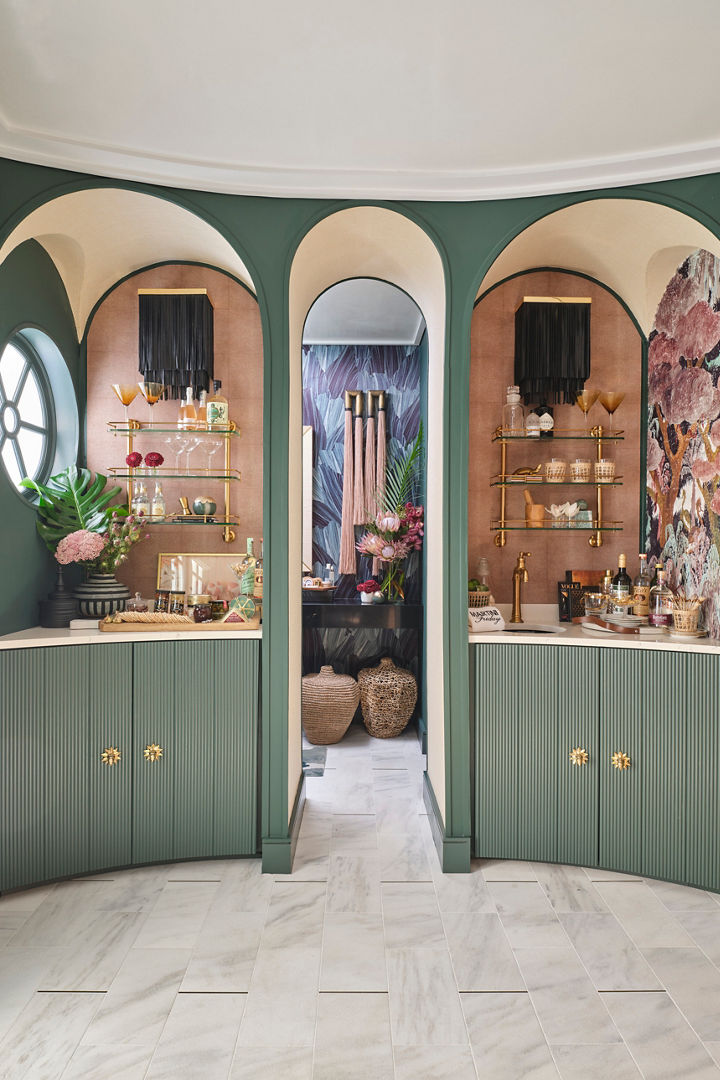 a gorgeous pool ball with sage green cabinets, white quartz countertops, rounded nook with open shelving, and an arched doorway.