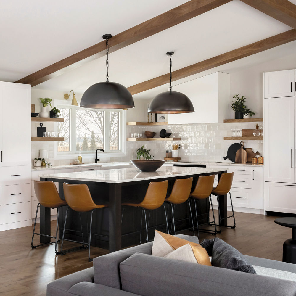 A kitchen with open wood shelving, vaulted ceilings with wooden beams, white cabinets and gorgeous center island with wooden barstools topped with Colton quartz countertops