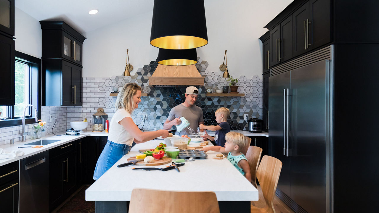 Morgan and Jamie Molitor with their kids in their renovated kitchen featuring Delgatie Matte™ quartz countertops.