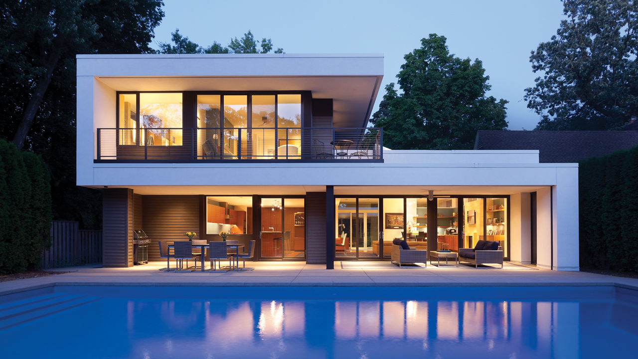 An exterior shot of a modern home with a pool.