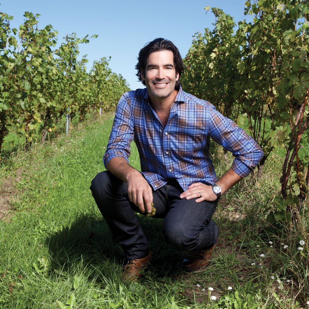 Carter Oosterhouse posing in a wine vineyard.